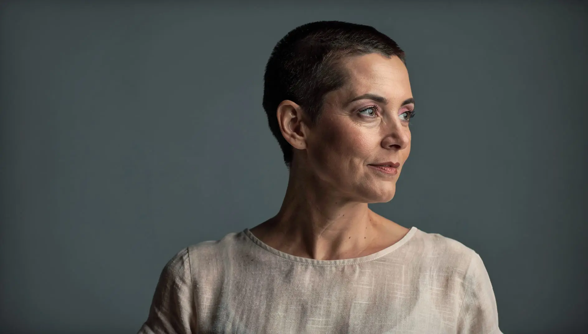A cancer survivor with a short crop, looking out toward the light